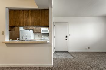 A kitchen with white appliances and a white door.